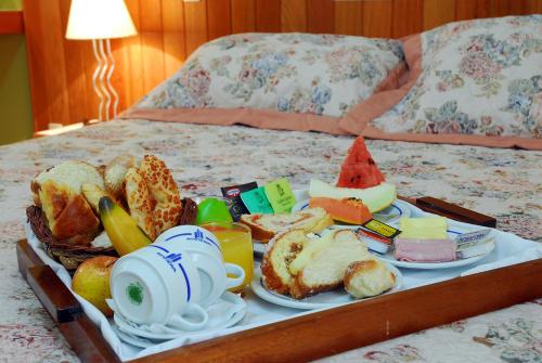 bandeja de alimentos para el desayuno en una cama en Hotel Riviera, en São José do Rio Preto