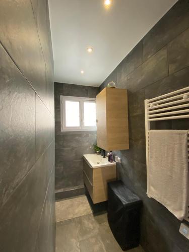 La salle de bains est pourvue d'un lavabo, d'un comptoir et d'une fenêtre. dans l'établissement Jerickais House à Bezons, à Bezons