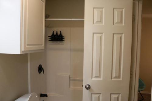 a bathroom with a white door next to a toilet at Lubbock haven Rooms with individual Bathrooms in Lubbock