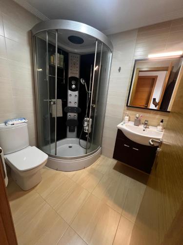 a bathroom with a shower and a toilet and a sink at Duplex Playa de Foz in Foz