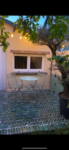 une table et des chaises devant un bâtiment dans l'établissement Cottage familial avec jardin à Dives-sur-Mer, à Dives-sur-Mer