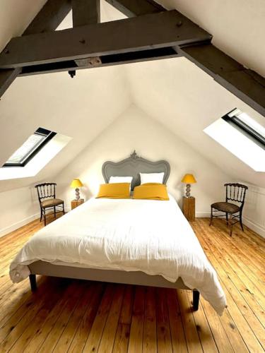 une chambre avec un grand lit dans un grenier dans l'établissement Duplex de charme à Valognes, à Valognes