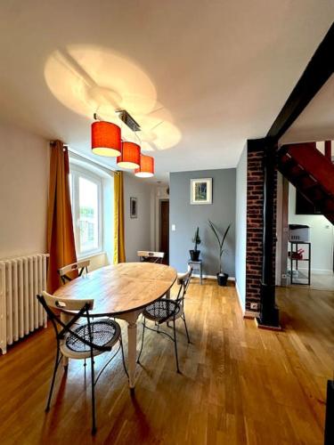 un salon avec une table et des chaises en bois dans l'établissement Duplex de charme à Valognes, à Valognes
