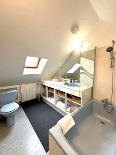 une salle de bain avec toilettes, baignoire et lavabo dans l'établissement Duplex de charme à Valognes, à Valognes
