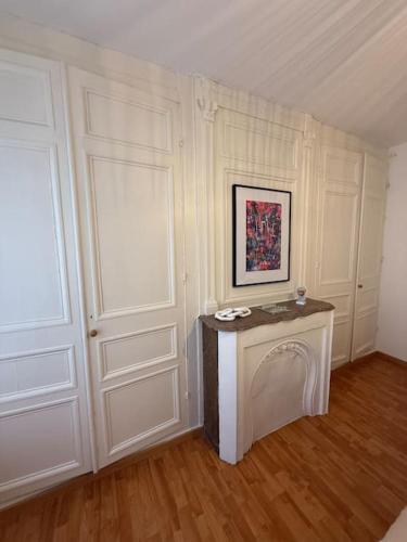 Cette chambre blanche dispose d'une porte et d'une table. dans l'établissement Cosy d'Opale, 4 pers, proche vielle ville, wifi, à Boulogne-sur-Mer