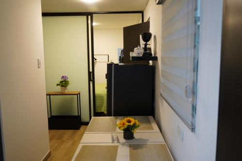 a room with a table and a refrigerator at Apartamento Flor de Azúcar - Casa Tartaruga Bogotá in Bogotá