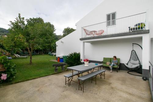 a woman sitting on a couch in the backyard of a house at Maria's Haven in Santo António