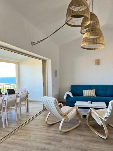 un salon avec un canapé bleu et des chaises dans l'établissement T4-80m2 superbe vue mer Sant Ambroggio, à Lumio