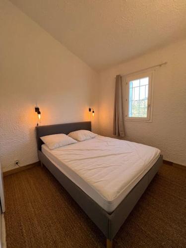 un grand lit dans une chambre avec une fenêtre dans l'établissement T4-80m2 superbe vue mer Sant Ambroggio, à Lumio