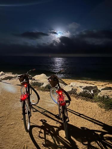 two bikes parked on the beach with the moon in the sky at Vilador Barcelona Beach Hotel in Masnou