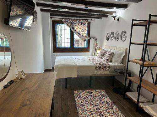 a bedroom with a bed and a shelf and a window at Vilador Barcelona Beach Hotel in Masnou
