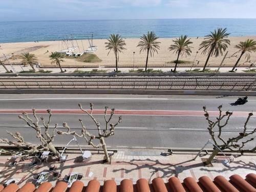 a view of a road with palm trees and the beach at Vilador Barcelona Beach Hotel in Masnou