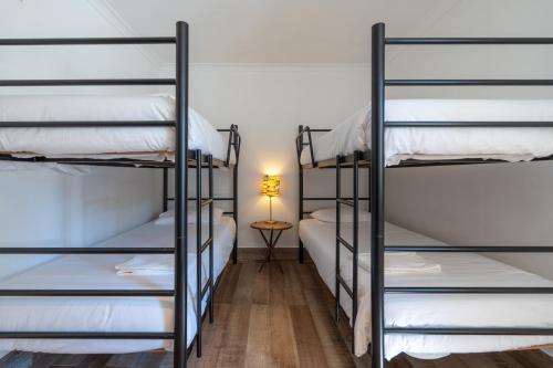 a room with four bunk beds with a lamp at Cazal d'Oliveira in Granja