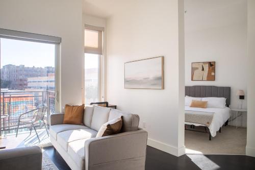 a living room with a couch and a bed at Modern Studio Apt with Rooftop, Gym, and Parking in Milwaukee