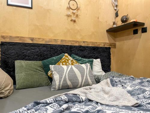 a bed with a bunch of pillows on it at Bouda Krušnohorka in Vojkovice