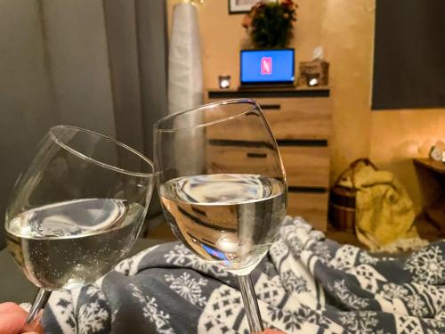 two glasses of white wine sitting on a table at Bouda Krušnohorka in Vojkovice