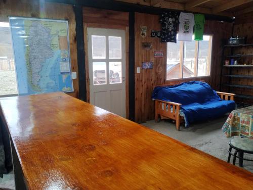 una gran mesa de madera en una habitación con escritorio en Hospedaje 73 M, en Gobernador Gregores