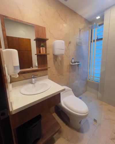 a bathroom with a white toilet and a sink at Amplio Departamento Familiar en Loja in Loja