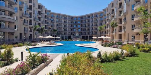 a large apartment building with a large swimming pool at Princess Resort Hurghada in Hurghada