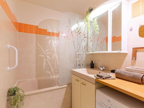 une salle de bain avec une baignoire, un lavabo et un miroir dans l'établissement Confort au centre de Saint Lary: T3 avec balcon, cuisine équipée - FR-1-296-505, à Saint-Lary-Soulan