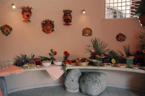 a table with food on it with plants on the wall at Hotel Villaggio Cala Di Volpe in Capo Vaticano