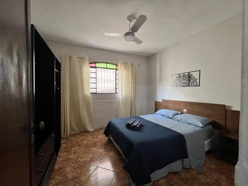 una camera da letto con un letto con una coperta blu di Tradição e Conforto em Santa Efigênia a Belo Horizonte