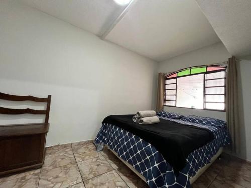 una camera da letto con un letto e una finestra di Tradição e Conforto em Santa Efigênia a Belo Horizonte