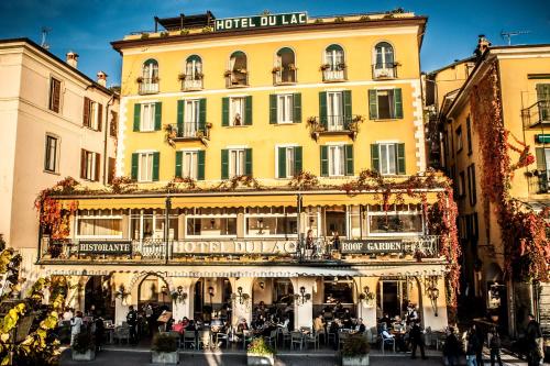a large yellow building with people sitting outside of it at Hotel Du Lac & SPA in Bellagio