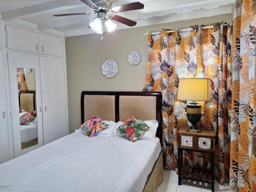 a bedroom with a bed and a ceiling fan at Norms Near US Embassy in Bridgetown