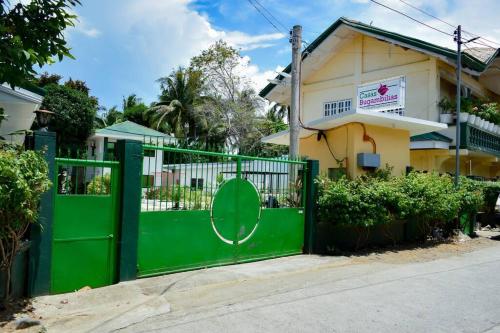 a green gate in front of a house at Casa Bugambilia Downstairs Unit in Balamban