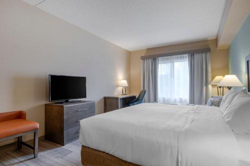 a hotel room with a bed and a flat screen tv at Comfort Inn & Suites Boulder in Boulder