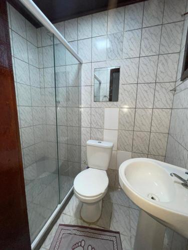 a white bathroom with a toilet and a sink at Pousada Terra Do Sol in Arraial do Cabo