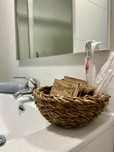a basket on a bathroom sink with a mirror at Apartamento Turístico Centro Antequera B in Antequera