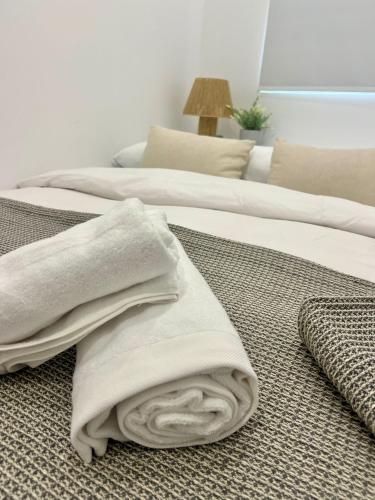 two beds with towels on the floor in a room at Apartamento Turístico Centro Antequera B in Antequera