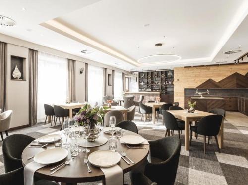 a restaurant with tables and chairs in a room at AR TATRY Hills in Štrbské Pleso