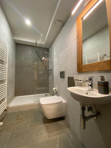 a bathroom with a toilet and a sink and a shower at AR TATRY Hills in Štrbské Pleso