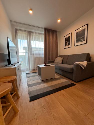 a living room with a couch and a television at AR TATRY Hills in Štrbské Pleso