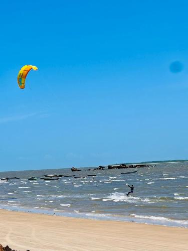 a person is flying a kite on the beach at Casa de Praia Tutóia in Tutóia