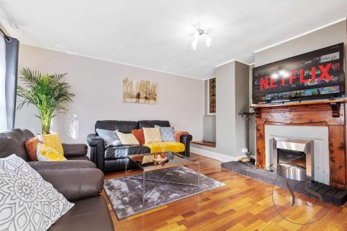 a living room with a couch and a fireplace at 4BR Family Home in 89 Highgate with Jacuzzi, Games Room & Free Parking Near Birmingham in Walsall