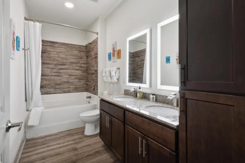 Un baño con dos lavabos, una bañera y un inodoro. en Overlook 5001i Luxury Accommodations I Pool, en Knoxville