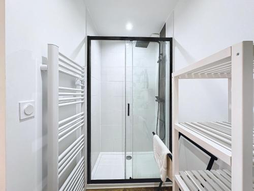 La salle de bains est pourvue d'une douche en verre et de murs blancs. dans l'établissement Ty Podic, à Brest