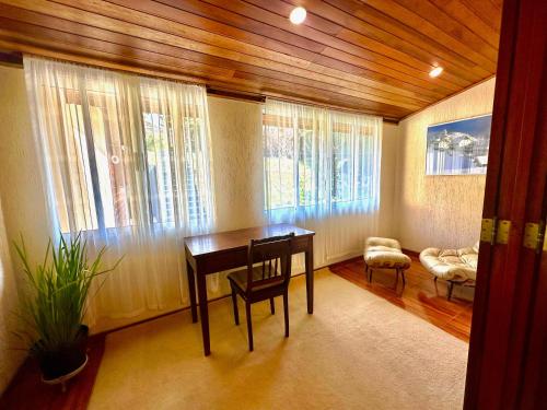 a room with a table and chairs and windows at Recanto Due Fratelli in Campos do Jordão