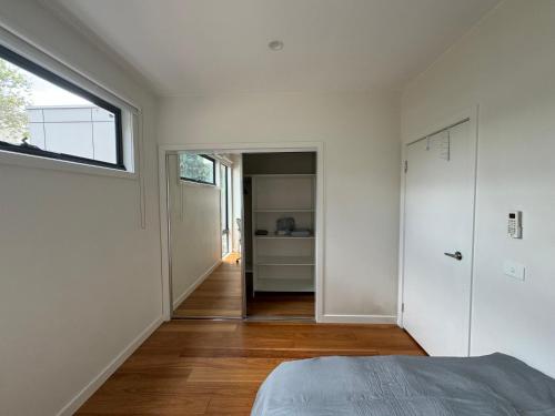 a bedroom with a bed and a hallway with a window at Quiet and Cozy corner in Braybrook