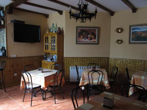 comedor con 2 mesas y TV en Apartamentos Haza La Moraleda, en Güéjar-Sierra