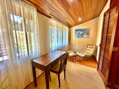 a dining room with a table and a chair at Recanto Due Fratelli in Campos do Jordão