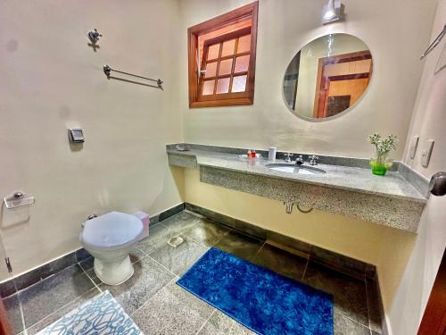 a bathroom with a toilet and a sink and a mirror at Recanto Due Fratelli in Campos do Jordão