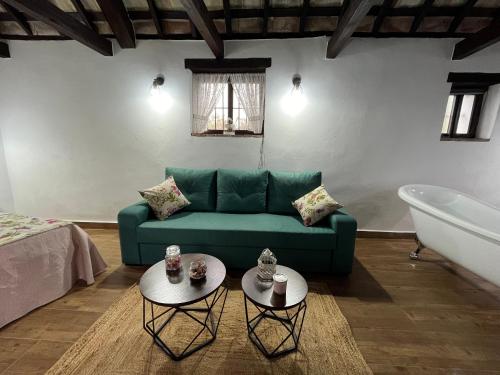 a living room with a green couch and a tub at Molino Angorrilla in Cádiz