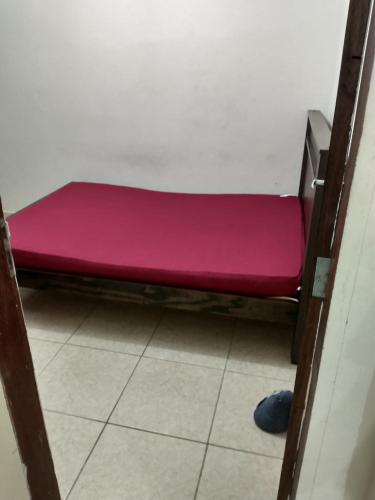 a small pink bed in a room with a floor at Apartamento Piuma ES in Piúma