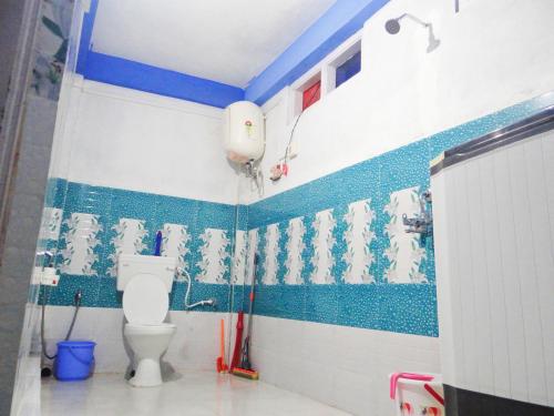 a bathroom with a toilet and blue and white tiles at Sangti Ngoedrup Homestay in Dirang Dzong
