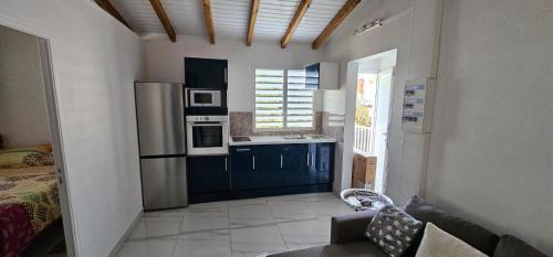 a kitchen with a couch and a refrigerator at Dyna condo one in Sainte-Rose